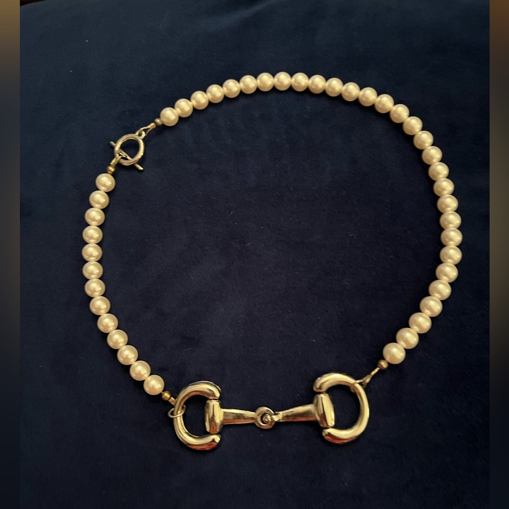 Women’s equestrian theme faux pearl necklace with off-center horsebit. 18” long.